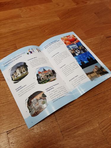A Lépj Feljebb kiadvány belíve, középen van kinyitva, fotókkal gazdagon illusztrálja a projekt keretében tartott programokat (pl. tropicárium, kastélylátogatás, Tata)