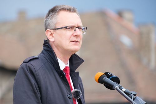 Rétvári Bence beszél, előtte mikrofonok