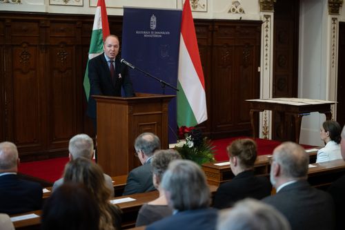 Pálmai Gergely áll a pulpituson, jobbról-balról magyar zászló, előtérben emberek, akik hallgatják