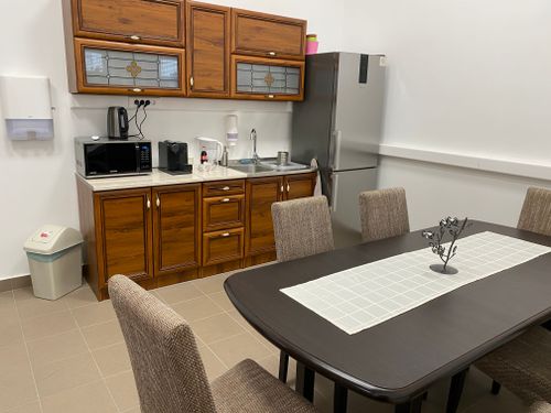 A DKA épület konyhája, előtérben az asztal, háttérben a szekrény, kávéfőzővel